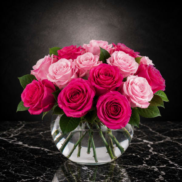 Pink and hot pink roses arranged in a clear glass vase