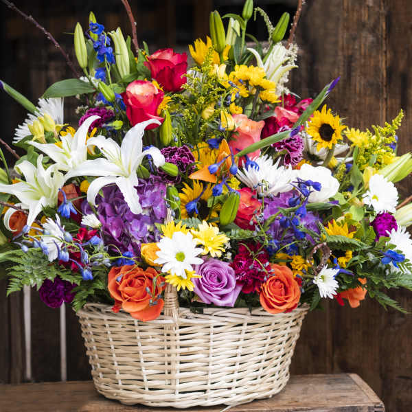 Colorful mixed flower arrangement in a wicker basket