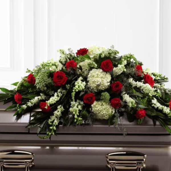 Red roses and white flowers arranged on a casket