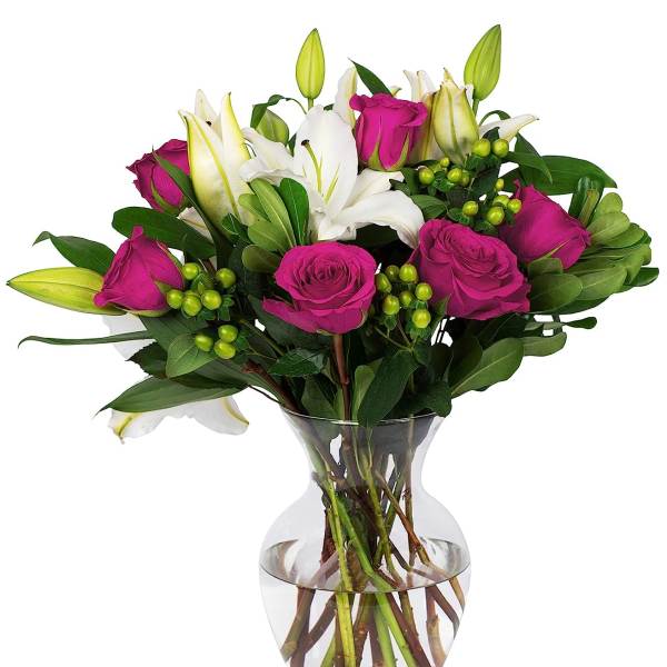 Clear glass vase of bright pink roses and white lilies with green accents