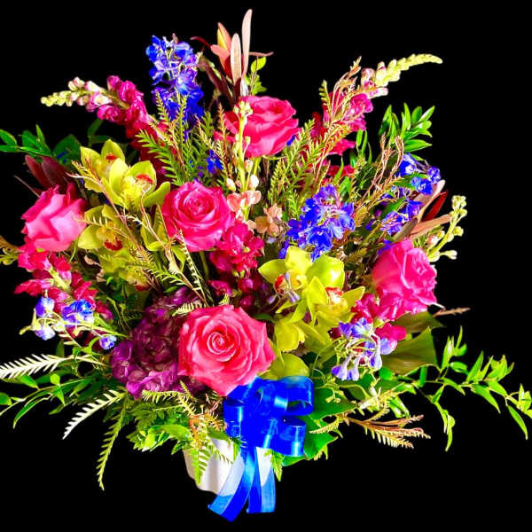 Bright mixed bouquet of pink roses, blue flowers, and yellow orchids