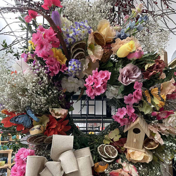 Large floral wreath with pink blooms, butterflies, and a burlap bow