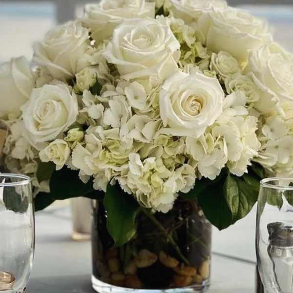 White roses and hydrangeas arranged in a glass vase