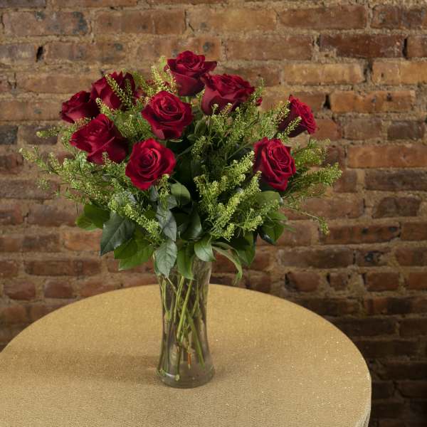 Red roses arranged in a clear glass vase