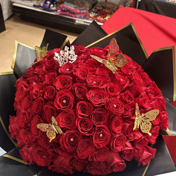 Large bouquet of red roses with butterfly decorations in black and gold wrap