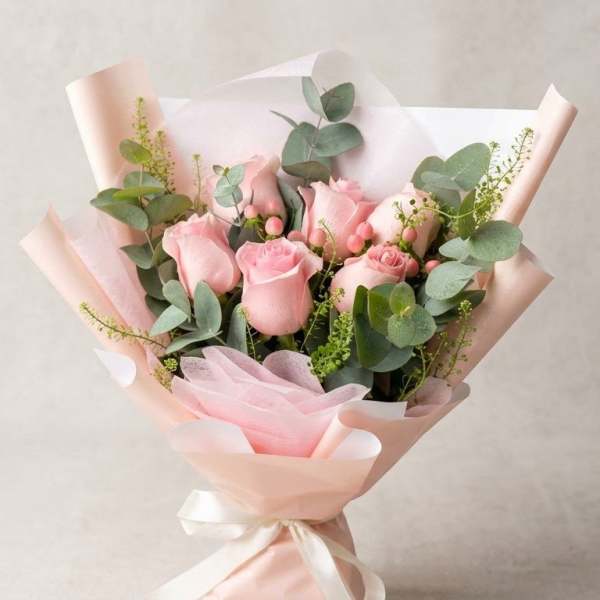 Bouquet of pink roses wrapped in pale pink paper