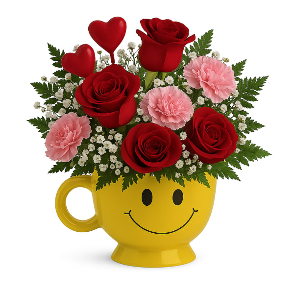 Red roses and pink carnations in a yellow smiley-face mug
