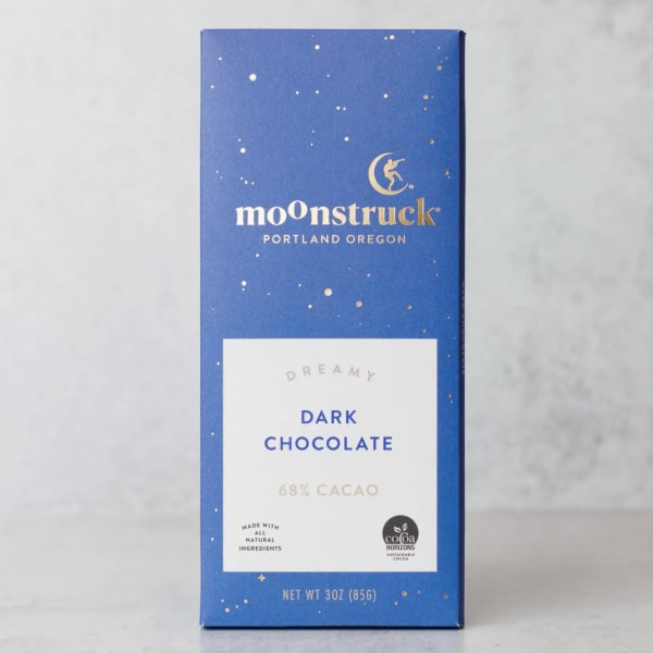Blue box of dark chocolate bar standing upright on a light gray surface