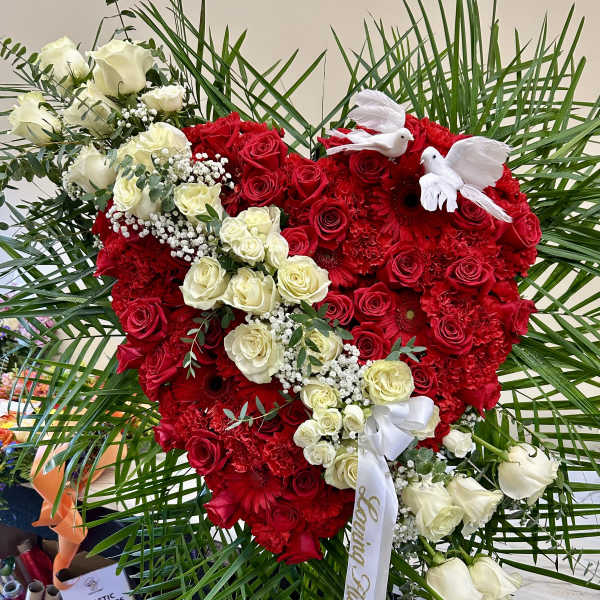 Heart-shaped red and white rose arrangement with white doves