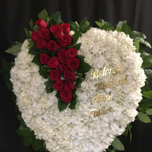 Heart-shaped floral tribute with white hydrangeas and red roses