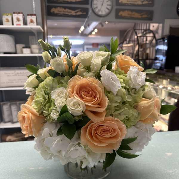 Peach and white rose bouquet with hydrangeas in a glass vase