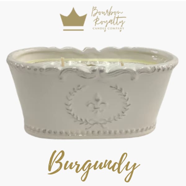 White ceramic candle vessel with gold logo and text
