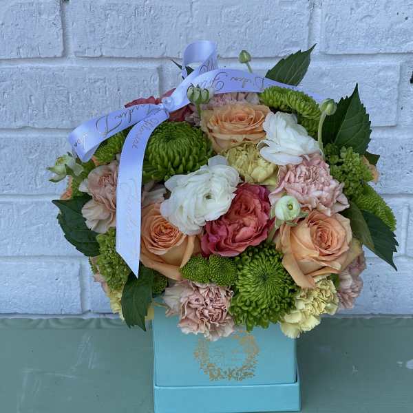 Mixed bouquet of roses and green chrysanthemums in a blue box with ribbon