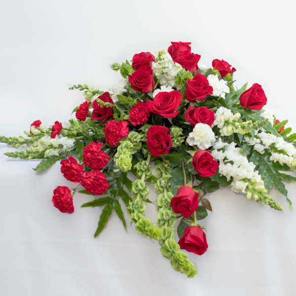 Red roses and white flowers arranged in a low spray