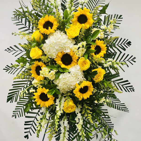 Tall standing floral spray with sunflowers, yellow roses, and white blooms