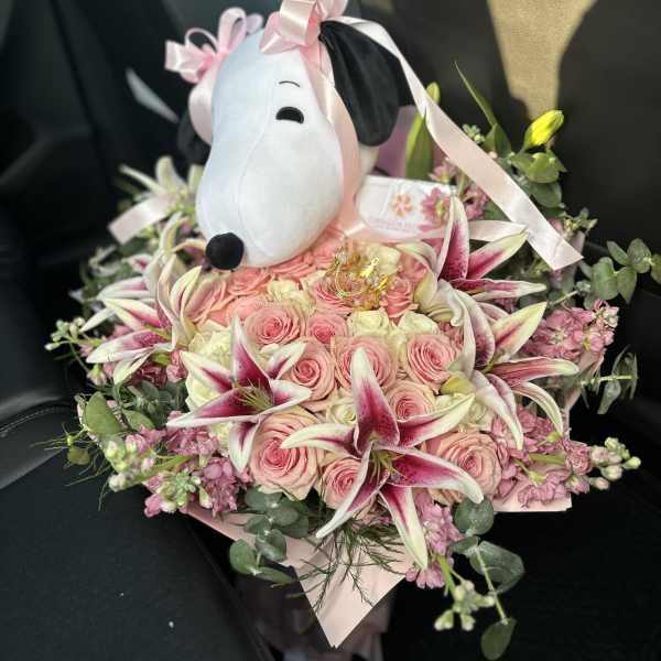 Pink rose bouquet with lilies and a Snoopy plush topper