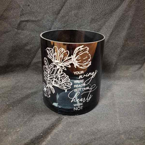 Black memorial candle holder with white floral line art and text