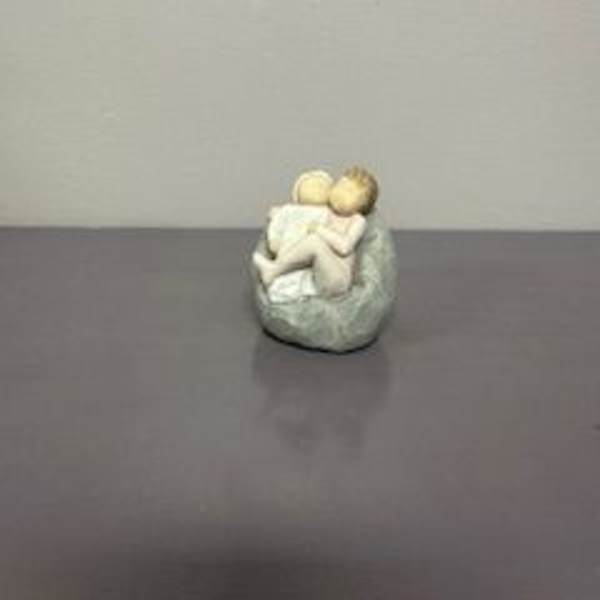 Small figurine of two seated figures in a rounded chair