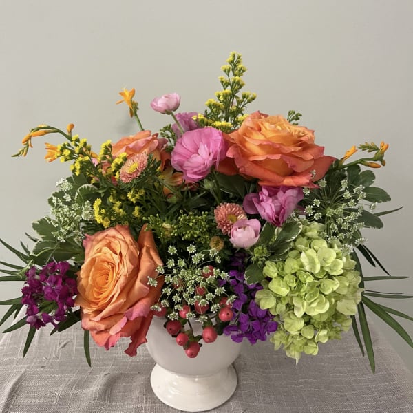 Colorful mixed bouquet in a white pedestal vase
