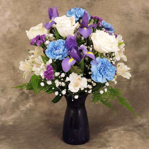 Purple and blue mixed bouquet in a dark vase