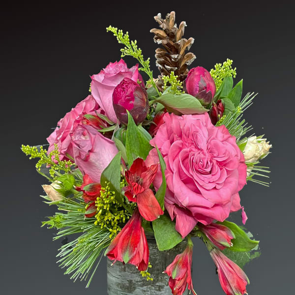 Pink roses and red alstroemeria in a rustic vase