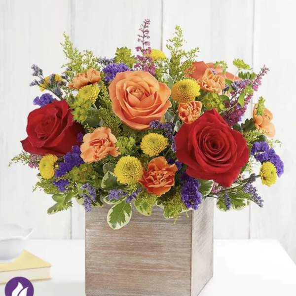 Mixed bouquet of roses, carnations, and button mums in a wooden box