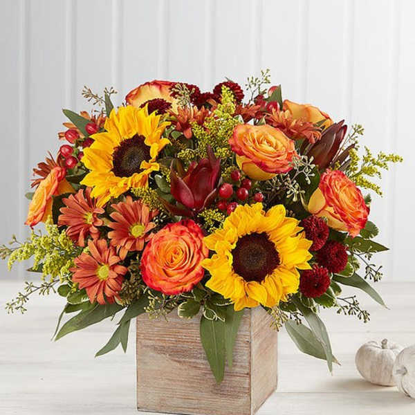 Autumn bouquet of sunflowers, roses, and mums in a wooden box