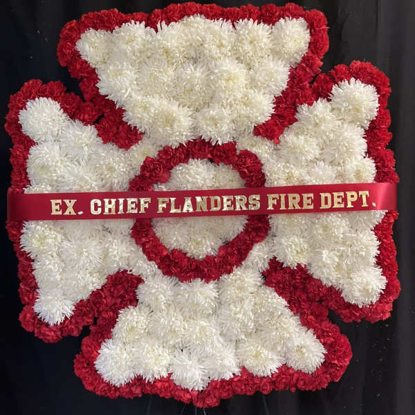 Red and white floral funeral tribute with a ribbon reading EX. CHIEF FLANDERS FIRE DEPT.