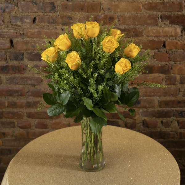 Yellow roses arranged in a clear glass vase