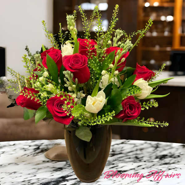 Red and white roses arranged in a dark vase