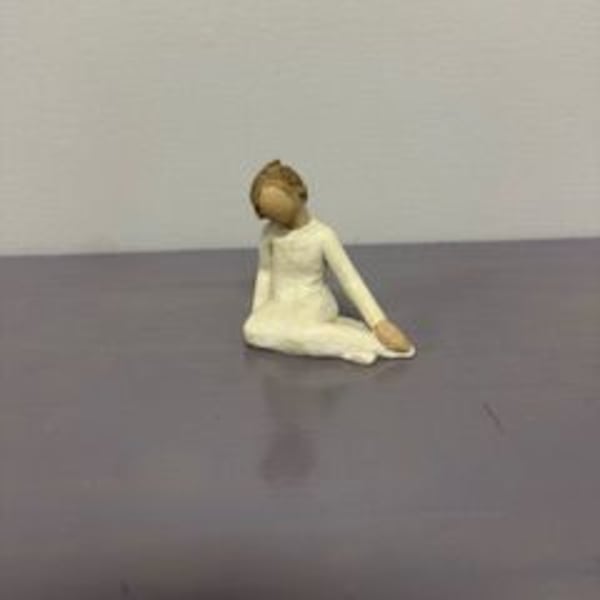 Small figurine of a seated person in a white outfit