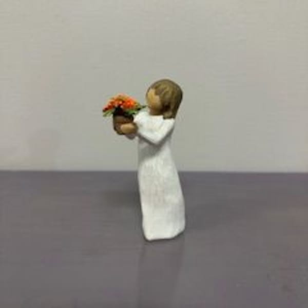 Small figurine of a child holding a tiny flower pot