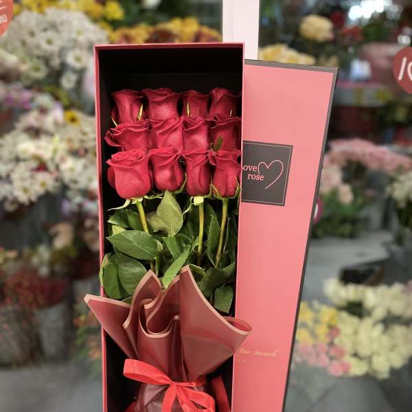 Boxed bouquet of red roses with a ribbon tie