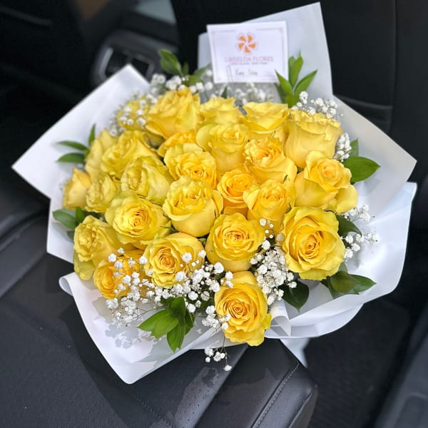 Bouquet of yellow roses with white baby's breath in white wrapping