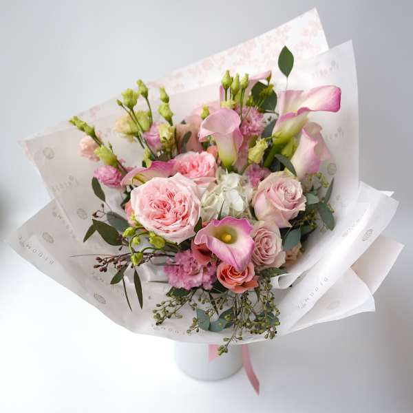 Pink and white bouquet with roses and calla lilies in paper wrap