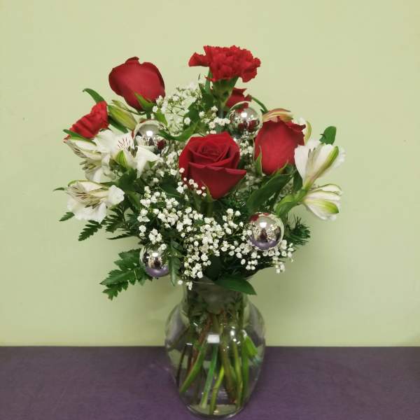 Red roses and white alstroemeria in a clear glass vase