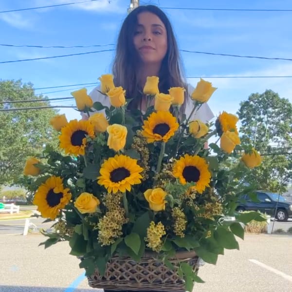 Large basket arrangement of yellow roses and sunflowers