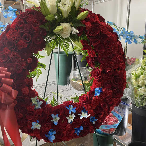 Large red rose wreath with a bow and white lilies