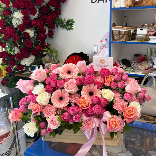 Large pink and red rose arrangement with gerbera daisies in a wooden box