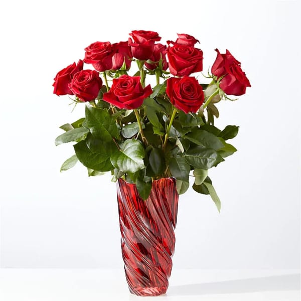 Arrangement of red roses in a tall red swirled glass vase