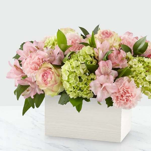 Pink and green floral arrangement in a white box