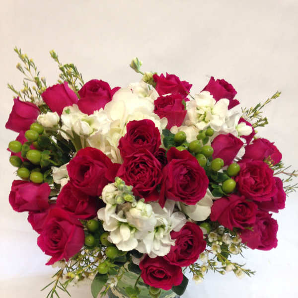 Bouquet of red roses and white flowers in a glass vase
