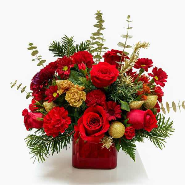 Red roses and red chrysanthemums in a red glass vase with gold accents