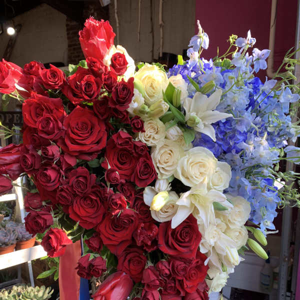 Large bouquet of red, white, and blue flowers on a stand