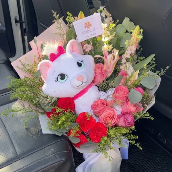 Bouquet of pink roses and lilies with a plush cat toy
