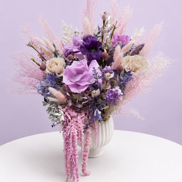 Lavender and pink floral arrangement in a white vase