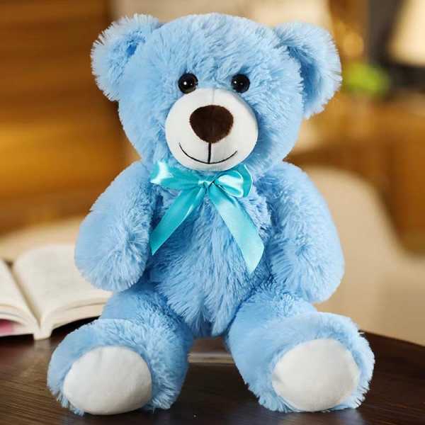 Blue teddy bear with a satin ribbon sitting on a table
