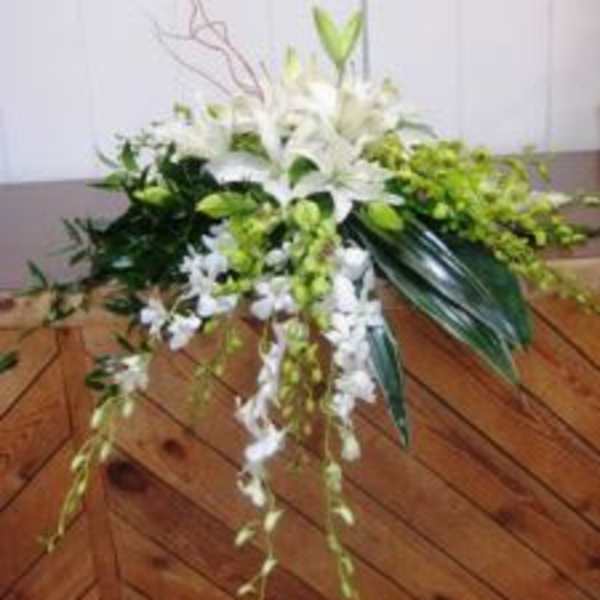 White lily arrangement with cascading orchids and green accents