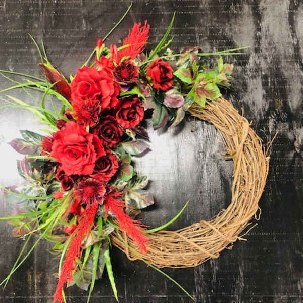Red floral wreath on a straw ring base