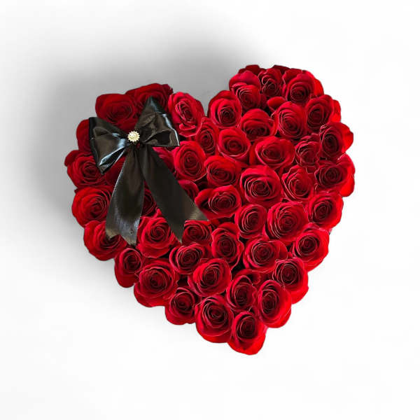 Heart-shaped arrangement of red roses with a black ribbon bow